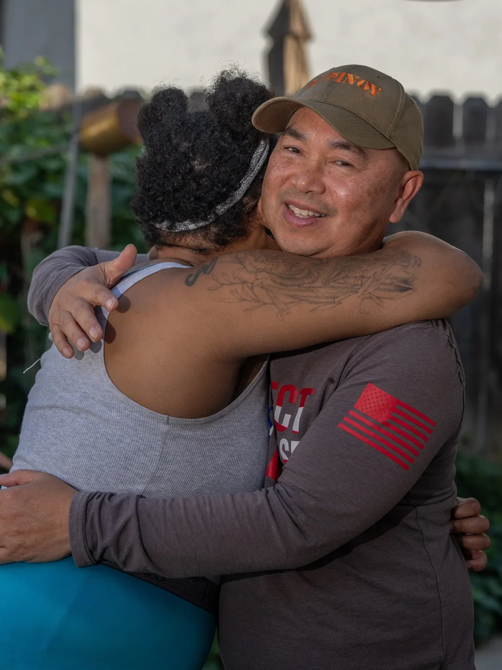 Caregiver and resident sharing a supportive embrace outdoors at residential care facility